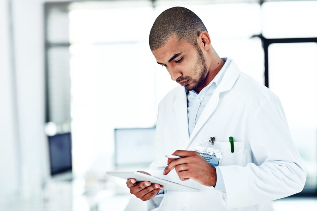 Shot of a scientist recording his findings on a digital tablet.